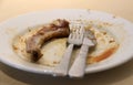 Pork bone with knife and fork in a dish is empty. Eaten plate of food. Royalty Free Stock Photo