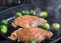 Pork and brussels sprouts on grill pan. Selective focus. Toned Royalty Free Stock Photo