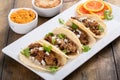 Pork carnitas tacos with onion and cilantro served with rice and refried beans