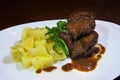 Pork cheeks in Demiglas sauce with boiled potatoes.