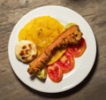 Pork chicharron with patacones and sliced tomatoes - Colombian traditional food