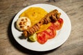 Pork chicharron with patacones and sliced tomatoes - Colombian traditional food