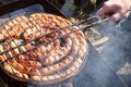 Pork and chicken sausages. Cooking on barbecue chargrill, brazier. Top view, closeup. Outdoors. Fast food. Preparation Royalty Free Stock Photo