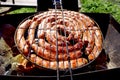 Pork and chicken sausages. Cooking on barbecue chargrill, brazier. Top view, closeup. Outdoors. Fast food. Preparation of sausages Royalty Free Stock Photo