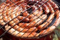 Pork and chicken sausages. Cooking on barbecue chargrill, brazier. Top view, closeup. Outdoors. Fast food. Preparation of sausages Royalty Free Stock Photo