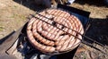 Pork and chicken sausages. Cooking on barbecue chargrill, brazier. Top view, closeup. Outdoors. Fast food. Preparation of sausages Royalty Free Stock Photo