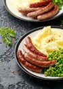 Pork Chipolata sausages with home cooked mashed potato and green peas