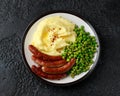 Pork Chipolata sausages with home cooked mashed potato and green peas Royalty Free Stock Photo