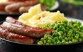 Pork Chipolata sausages with home cooked mashed potato and green peas