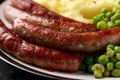 Pork Chipolata sausages with home cooked mashed potato and green peas