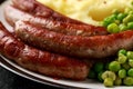Pork Chipolata sausages with home cooked mashed potato and green peas Royalty Free Stock Photo