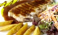 Pork chop and gravy with fries and salad Royalty Free Stock Photo