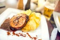 Pork chop on grill with chips as main course at local restaurant, fancy dish from american cuisine