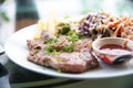 Pork chop steak with salad and gravy sauce in dish. Food and Veg Royalty Free Stock Photo