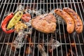 Pork chop steak and vegetable with sausage on a flaming BBQ grill Royalty Free Stock Photo