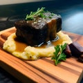 Beef tenderloin in sauce with potatoes on a cutting kitchen wooden board Royalty Free Stock Photo