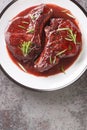 Pork chops on the bone fried and then cooked with red wine, herbs and spices close-up on a plate. Vertical top view Royalty Free Stock Photo