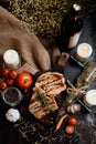 Pork chops steak with black pepper sauce placing on vintage wooden plate together with many ingredient and wine bottle Royalty Free Stock Photo