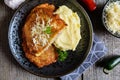 Pork cutlets coated in potato batter, studded with cheese and served with mashed potato