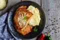 Pork cutlets coated in potato batter, studded with cheese and served with mashed potato