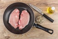 Pork cutlets in frying pan, spices, bottle of vegetable oil Royalty Free Stock Photo