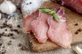 Pork dried meat slices on rustic dark wooden background. Dried pork prosciutto salami ham with herbs Royalty Free Stock Photo
