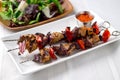 Pork kebabs skewers with sauce and salad