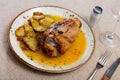 Pork knuckle baked in oven with boiled potatoes in white plate