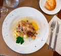 Pork knuckle baked in oven with boiled potatoes in white plate