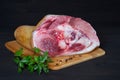 Pork knuckle with parsley and pepper peas lies on a wooden Board made of bamboo on a dark wooden background Royalty Free Stock Photo