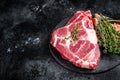 Pork loin steak, raw neck meat with thyme and salt. Black background. Top view. Copy space Royalty Free Stock Photo