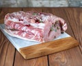 Pork loin stuffed with spices, garlic, pepper and bay leaf on a cutting board, wooden table Royalty Free Stock Photo
