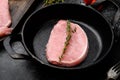 Pork meat. Fresh pork steaks, on frying cast iron pan, on black dark stone table background Royalty Free Stock Photo