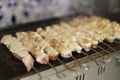 Pork meat on metal skewers being grilled for lunch in a Greek restaurant. Traditional souvlaki meat cooking on hot grill pan Royalty Free Stock Photo