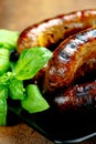 Pork meat sausages on a black plate Royalty Free Stock Photo