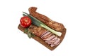 Pork meat tenderloin pastrami smoked and spiced, with thin slices, tomato and spring onion, on a wooden chopping board, isolated Royalty Free Stock Photo