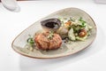 Pork medallion with bacon and fresh vegetables on grey plate isolated on white background Royalty Free Stock Photo