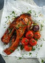 Pork middle chop roast with sweet and sour souce, baked tomatoes and red onion