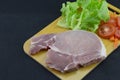 Pork put on a wooden cutting board with lettuce Carrots and tomatoes