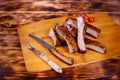 Meat pork ribs on a barbecue grill in the board on tomatoes on a wooden background flat lay Royalty Free Stock Photo