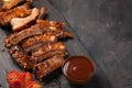 Pork ribs in barbecue sauce and honey roasted tomatoes on a black slate dish. A great snack to beer on a black stone background. T Royalty Free Stock Photo