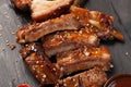 Pork ribs in barbecue sauce and honey roasted tomatoes on a black slate dish. A great snack to beer on a black stone Royalty Free Stock Photo