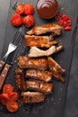 Pork ribs in barbecue sauce and honey roasted tomatoes on a black slate dish. A great snack to beer on a black stone background. T Royalty Free Stock Photo