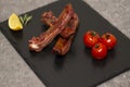Pork ribs in barbecue sauce and honey roasted tomatoes on a black slate dish. Royalty Free Stock Photo