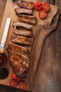 Pork ribs in barbecue sauce and honey roasted tomatoes on a wooden board. A great snack to beer on a rustic wooden table. Top view Royalty Free Stock Photo