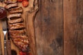 Pork ribs in barbecue sauce and honey roasted tomatoes on a wooden board. A great snack to beer on a rustic wooden table. Top view Royalty Free Stock Photo