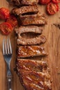 Pork ribs in barbecue sauce and honey roasted tomatoes on a wooden board. A great snack to beer on a rustic wooden table. Top view Royalty Free Stock Photo