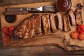 Pork ribs in barbecue sauce and honey roasted tomatoes on a wooden board. A great snack to beer on a rustic wooden table. Top view Royalty Free Stock Photo