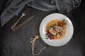 Pork ribs with beets, carrots, fried mushrooms and sauce on a white plate. Restaurant serving. Old black rustic background. Top vi Royalty Free Stock Photo