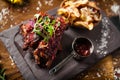 Pork ribs cooked at low temperature. Blackcurrant sauce, parsnip chips with Parmesan cheese. Delicious healthy meat food Royalty Free Stock Photo